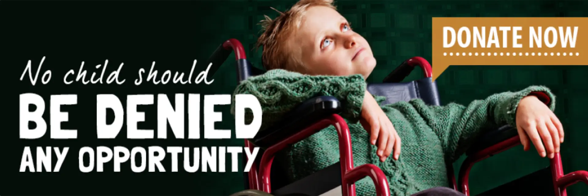 Young boy in wheelchair looking hopeful, wrapped in a green blanket.