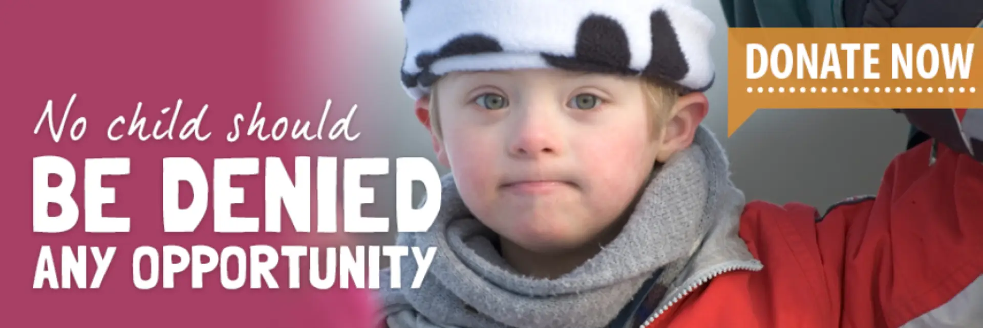 A young child in a cow-patterned hat with a serious expression.