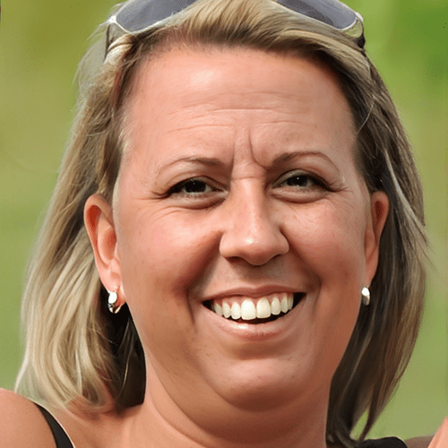 Smiling woman outdoors with sunglasses on her head.